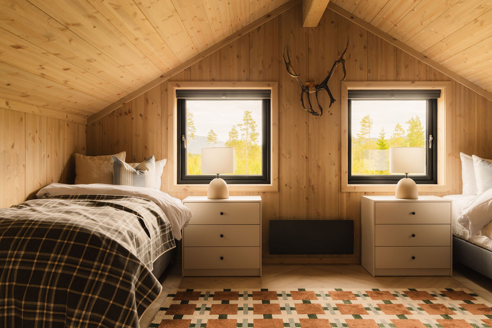 Slaapkamer met twee eenpersoonsbedden onder het schuine dak