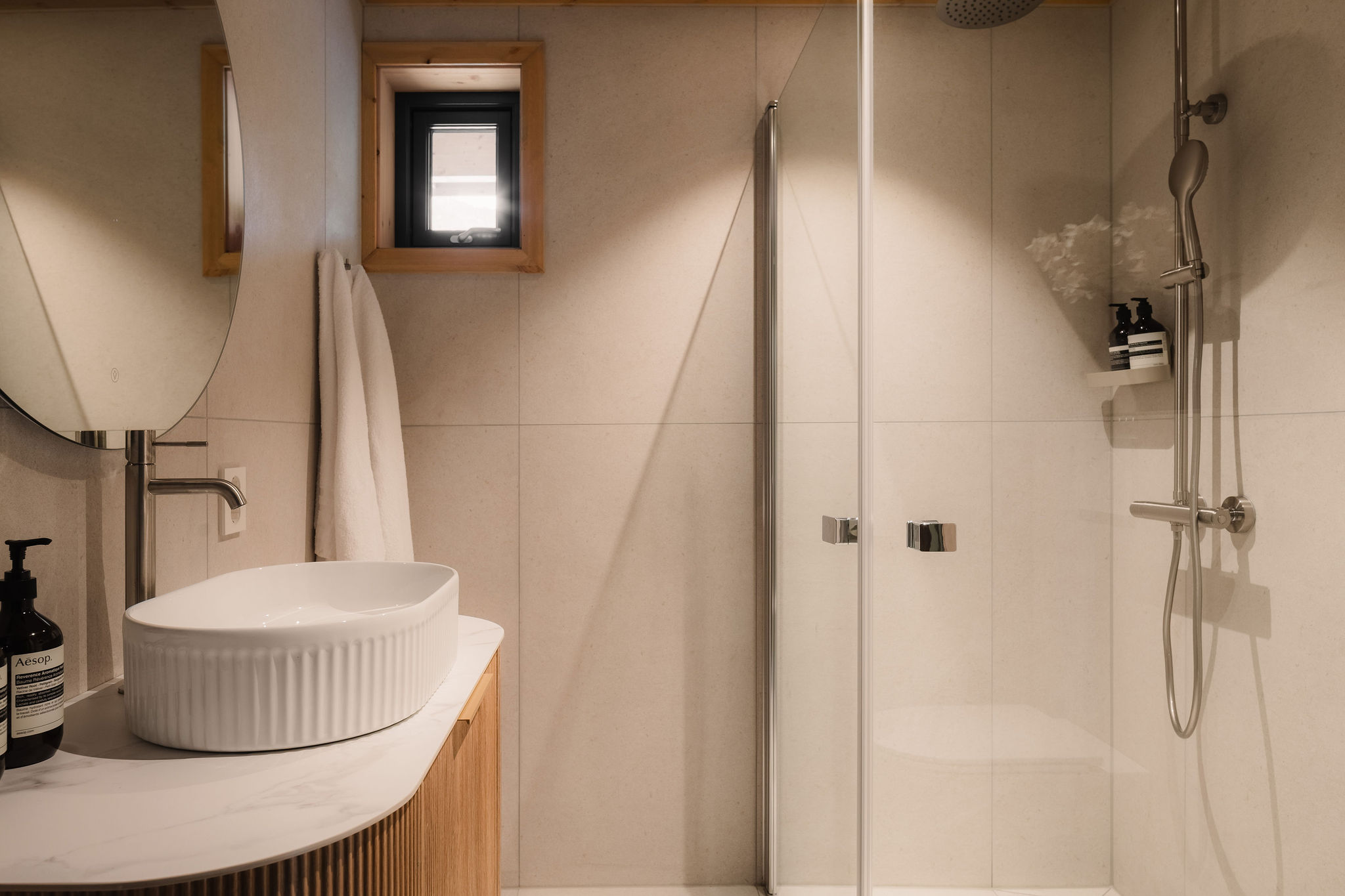 Badkamer met wastafel en glazen regendouche