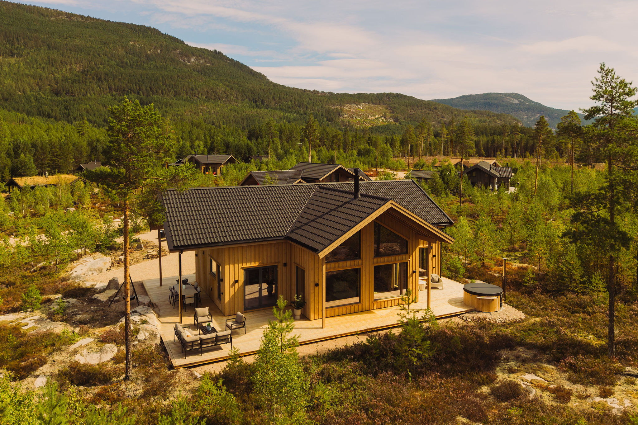 Villa Hygge van bovenaf, met het terras en de hot tub tussen de dennenbomen